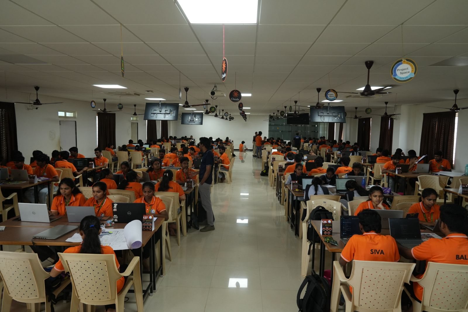 Project Space hall packed with student teams coding under Claude banners