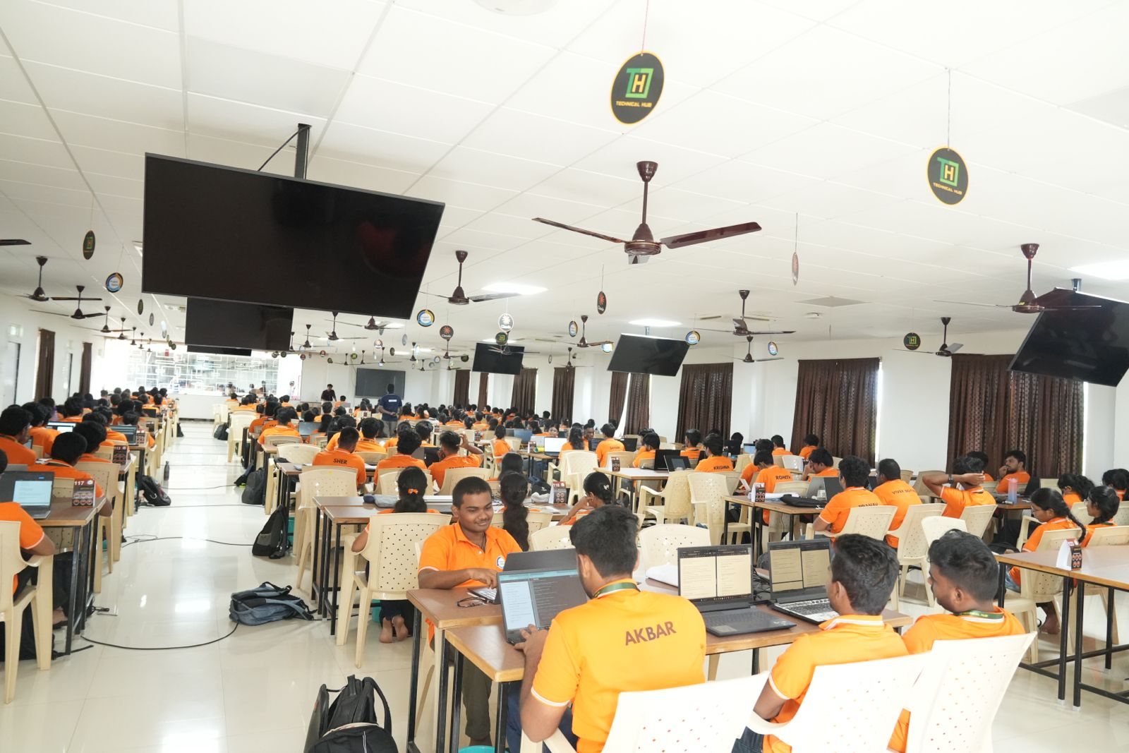 Rows of student teams working on laptops across the Project Space hall